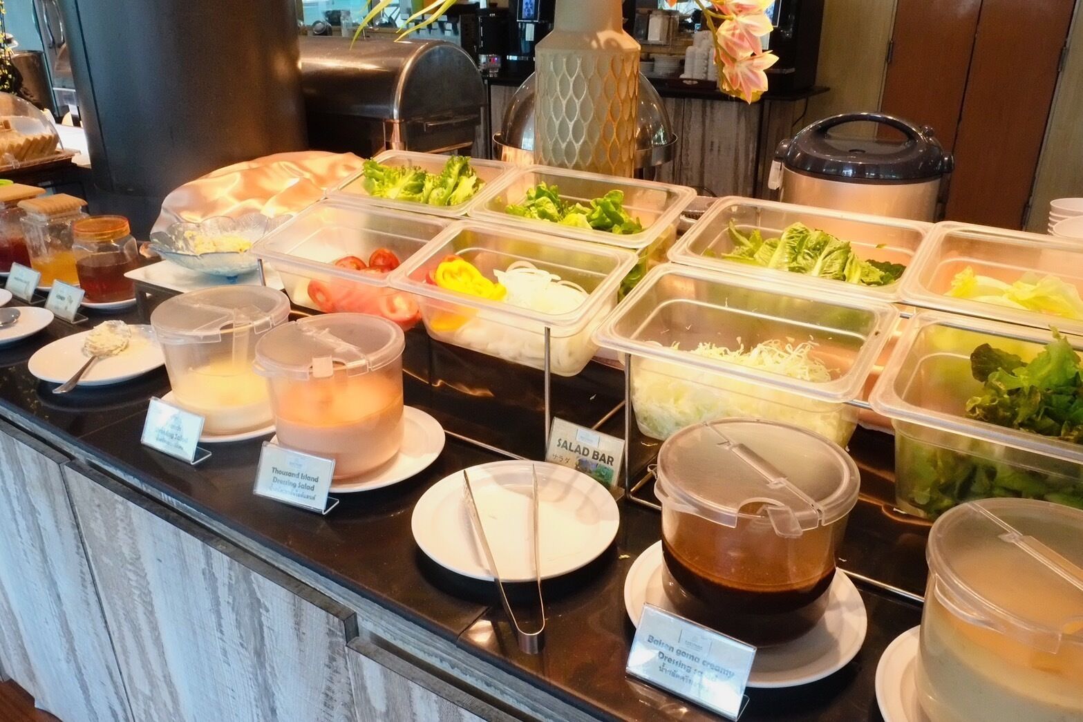 A buffet with various food options including salads, fruits, and beverages.