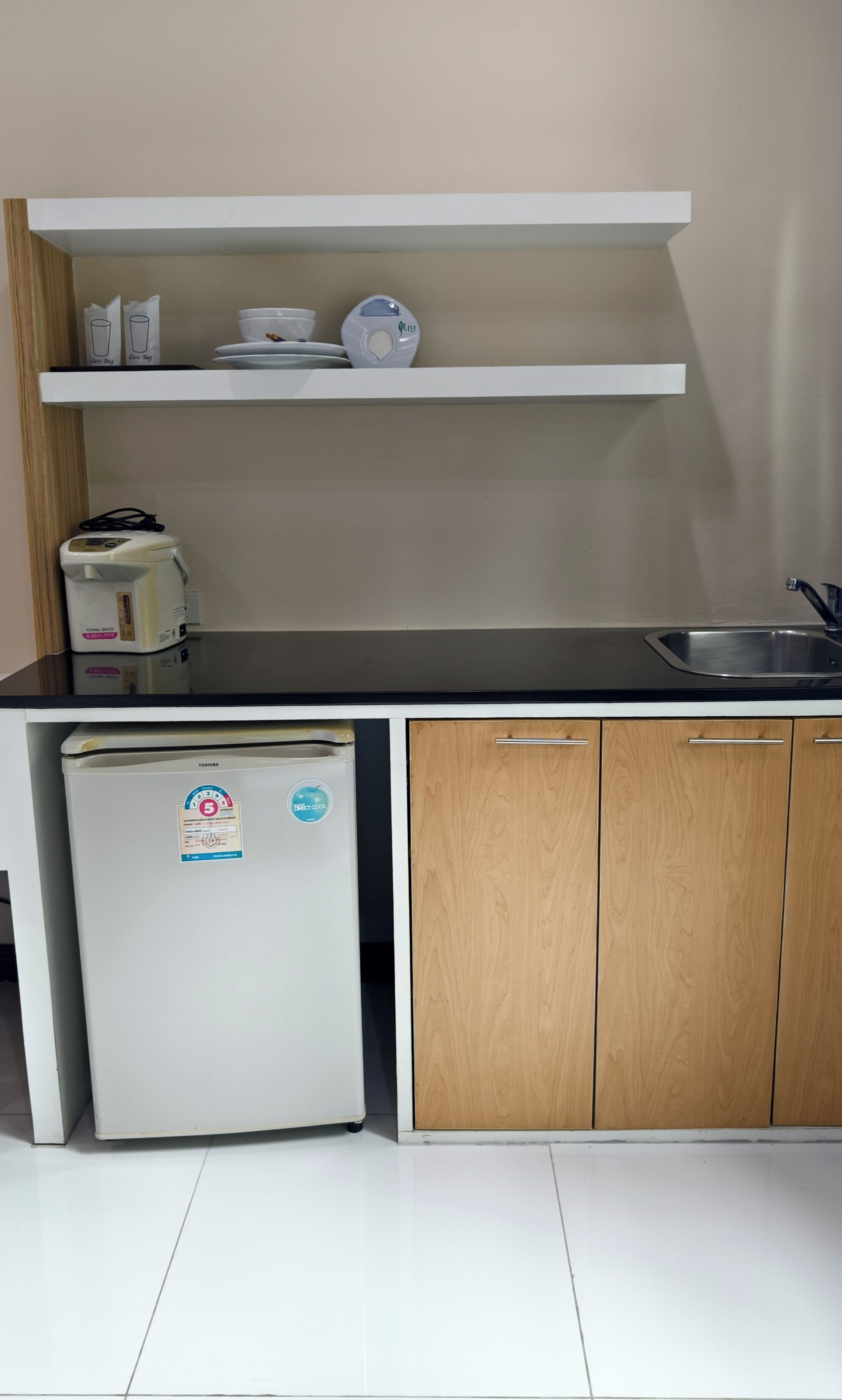 A compact kitchen with a refrigerator, a sink, and a countertop.