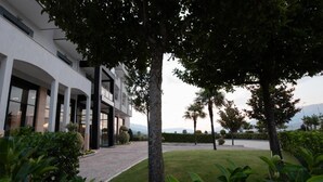 A modern building with a covered walkway and well-maintained landscaping. - El Nacional Hotel (Dropull i Poshtëm)