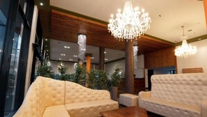 A modern lobby with plush seating, chandeliers, and large windows. - El Nacional Hotel (Dropull i Poshtëm)