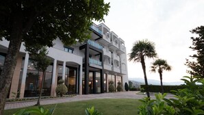 A modern hotel with a central courtyard, multiple balconies, and a well-maintained garden. - El Nacional Hotel (Dropull i Poshtëm)
