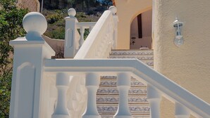 A white staircase with balustrades leading to a building entrance.