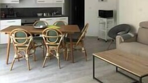 Ein modernes Wohnzimmer mit Esstisch und Stühlen, einer Couch und einem Couchtisch.