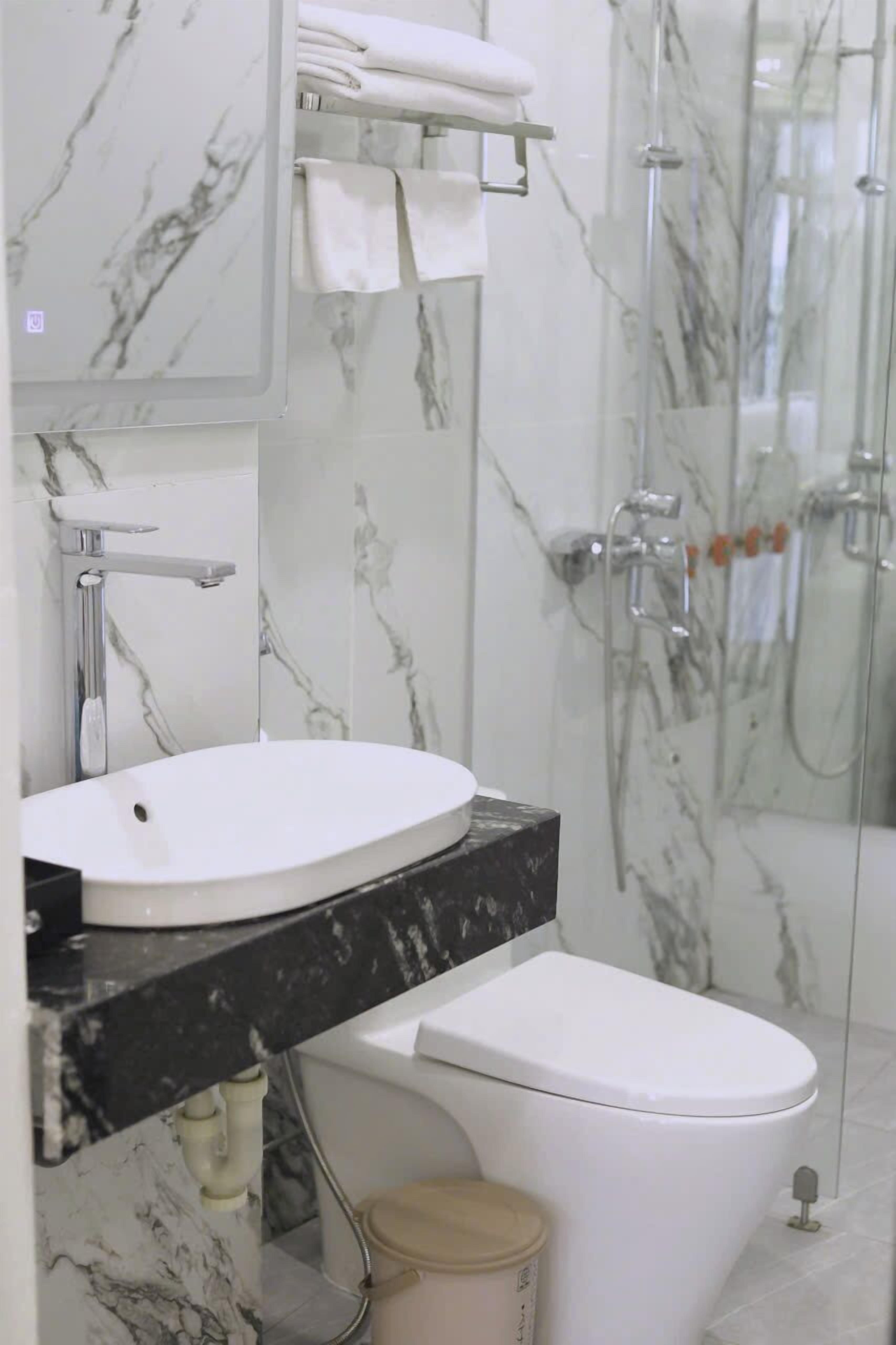 Ein Badezimmer mit Waschbecken, Toilette und einer Duschkabine.