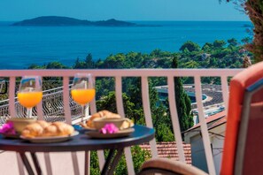 A balcony with a table set for breakfast, overlooking a coastal view with a distant island. - Hedera Estate, Villa Hedera XIX (Zupa dubrovacka)
