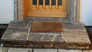 A wooden door with vertical bars and a keyhole, set in a stone frame. - Munich center just a 10-minute subway ride away: 130 m², 4 bedrooms, 2 bathrooms (München)