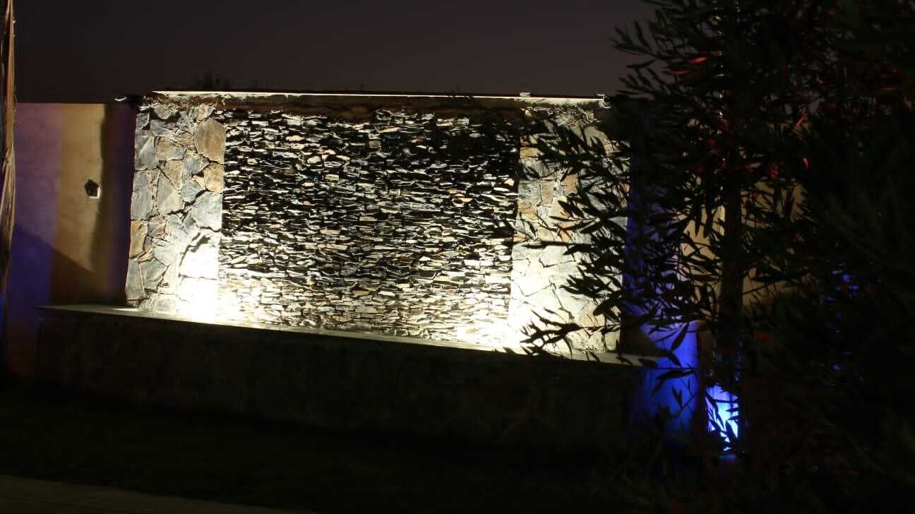 A stone wall with a textured surface and a small opening.