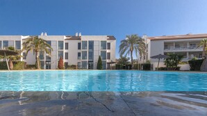 A swimming pool with a modern building in the background. - Samos Apartment (Badia de Xàbia)