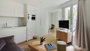 A modern living space with a kitchen, dining area, and seating area.