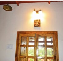 Puerta de madera con panel de vidrio, una lámpara de pared y una lámpara en el techo.