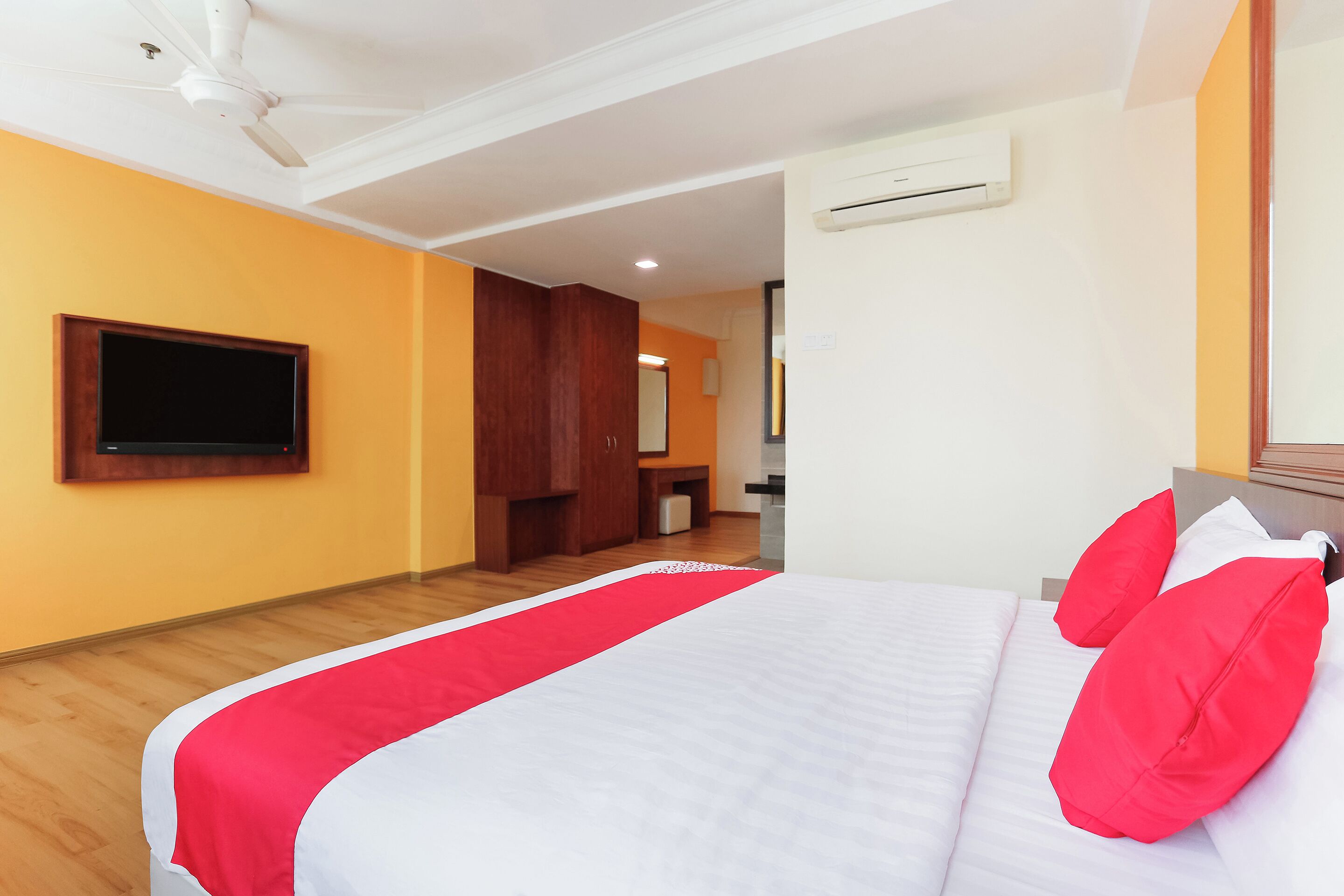 Une chambre d’hôtel équipée d’un lit, d’un téléviseur fixé au mur et d’un appareil de climatisation.