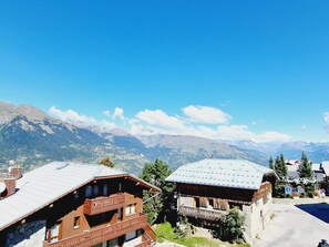 A mountain village with traditional wooden houses, a clear blue sky, and a view of distant mountains. - Luxury Apartment 170m², 5 Bedrooms, Ski Nearby, Parking, Wifi (La Plagne Montalbert)