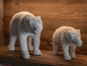 Two small bear figurines on a wooden shelf.