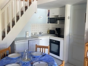 Een kleine keuken met een magnetron, koffiezetapparaat en een koelkast.