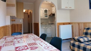 A compact living space with a dining area, kitchenette, and a cozy seating area.