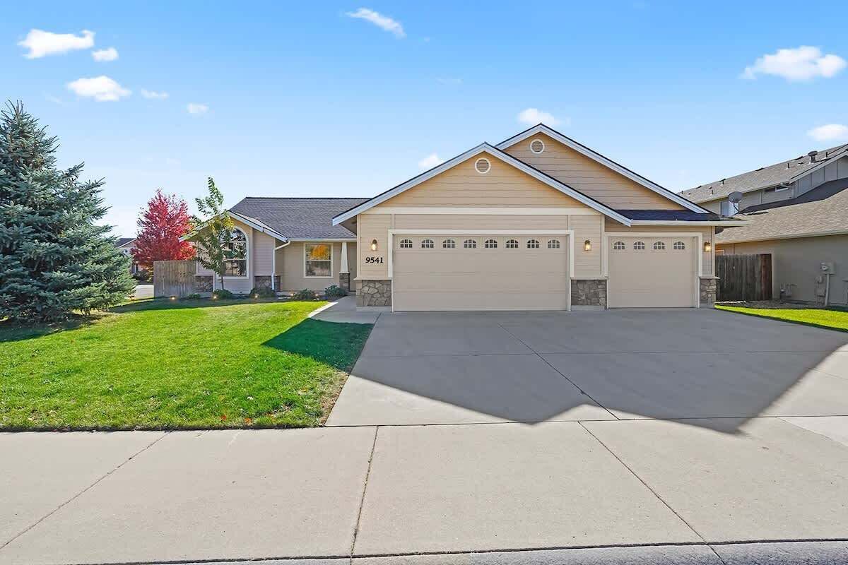 A single-story house with a garage, a well-maintained lawn, and a clear sky.