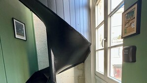 Eine Holztreppe mit schwarzer Handlauf zu einer Zwischenebene.