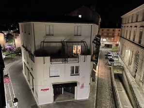 Un bâtiment blanc avec une enseigne de café, une porte de garage et un balcon.