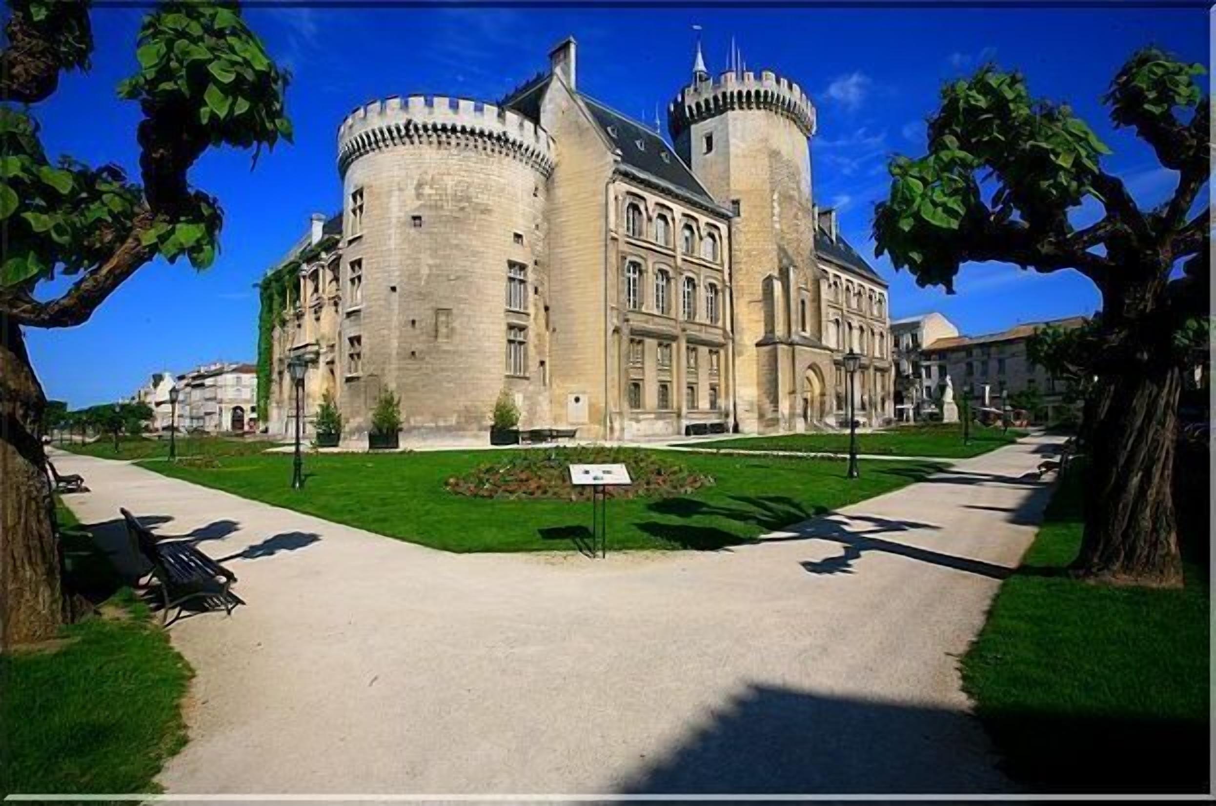 A historic building with a large courtyard, a central tower, and a symmetrical facade.