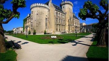 A historic building with a large courtyard, a central tower, and a symmetrical facade.