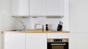 Een moderne keuken met witte kasten, een roestvrijstalen spoelbak, een broodrooster en een oven.