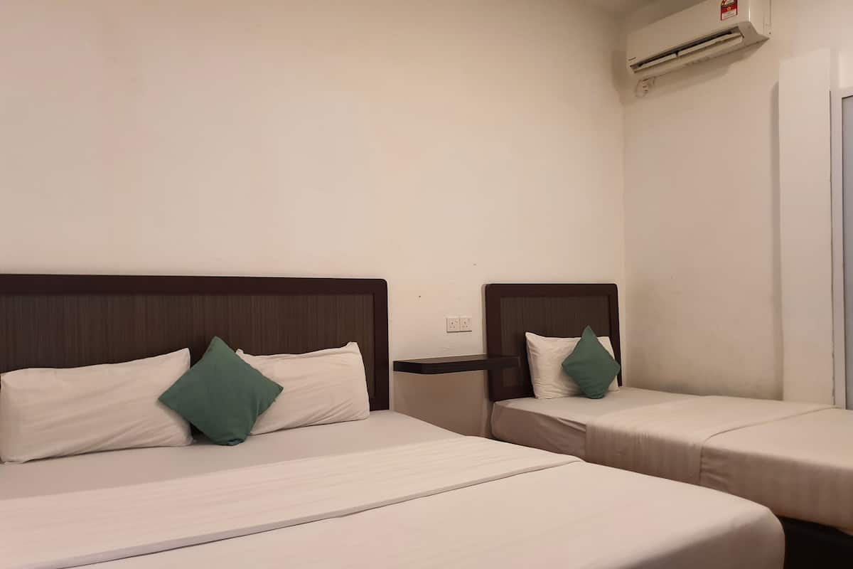 Two single beds with wooden headboards and white bedding, a wall-mounted air conditioner, and a power outlet.