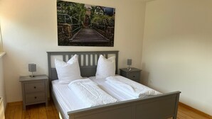 Un dormitorio con una cama, dos mesitas de noche y un cuadro colgado en la pared.