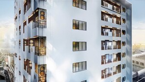 Een modern hoog gebouw met meerdere balkons en grote ramen.