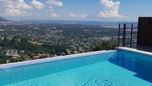 A clear blue swimming pool with a view of a cityscape and mountains in the background. - Kingston view (Kingston)