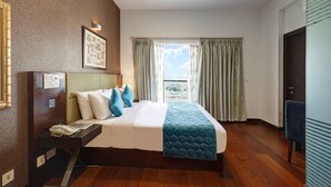 A hotel room with a large bed, a bedside table with a phone, a framed picture on the wall, and a view through the window. - Hotel 91 Golf Course Road (Gurugram)