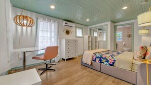 A bedroom with a bed, a desk, a chair, and a dresser. - Pink Bungalow! (Austin)