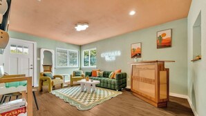 A living room with a green sofa, yellow armchairs, a coffee table, and a wooden cabinet.