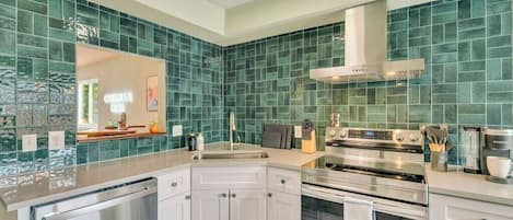 A modern kitchen with a stainless steel dishwasher, double oven, and a built-in espresso machine.