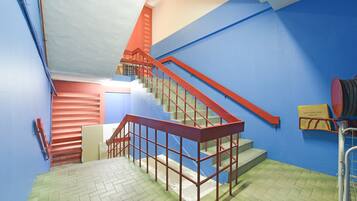 A multi-level interior with a staircase, railings, and a tiled floor.