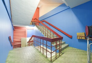 Ein mehrgeschossiges Interieur mit Treppe, Geländern und Fliesenboden.
