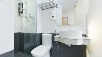 A modern bathroom with a glass shower enclosure, a white toilet, and a sink with a mirror above it.