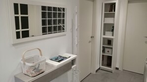 A bathroom with a white sink, a mirror, and a window with blinds. There is a basket on the sink and a white cabinet below it. - Laidatxu Beach Apartment in Mundaka (Mundaka)