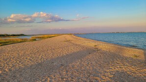 A pebbled beach with a calm sea and a clear sky.