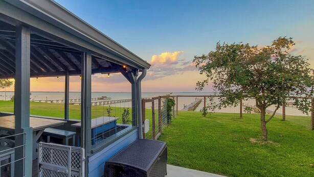 A covered outdoor area with tables and a view of the water.