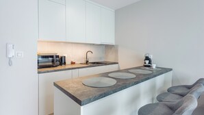 A modern kitchen with a built-in microwave, coffee maker, and sink. - Apartamenty Sun & Snow Kuracyjna Jastrzębia Góra (Wladyslawowo)
