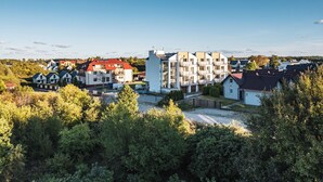 A modern residential building with multiple floors, large windows, and a central courtyard. - Apartamenty Sun & Snow Kuracyjna Jastrzębia Góra (Wladyslawowo)
