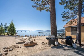 A beachside setting with a grill, picnic table, and lounge chairs. - Bearfoot Bungalow - Year Round Private Beach Access (Tahoe Vista)