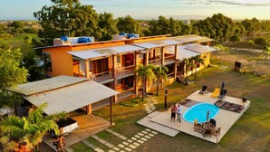 A modern house with a swimming pool, outdoor seating, and a large garden. - Camaleao Ecopousada Ltda (Linhares)