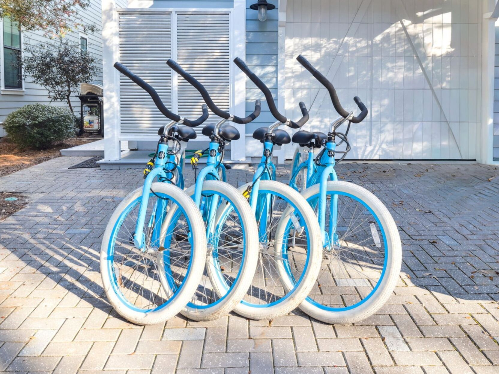 Trois vélos sont garés devant une maison qui a un garage.