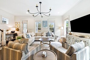 A spacious living room with a large sofa, armchairs, a coffee table, and a TV. - Watercolor! Next to Dragonfly Pool, LSV, + 4 Bikes! Serene Location! (Santa Rosa Beach)
