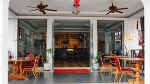 A hotel lobby with a reception desk, seating area with tables and chairs, and ceiling fans. - Royal Park Hotel (Kumasi)