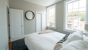 Una camera da letto con un letto, una ventola a soffitto e due finestre.