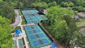 Un complexe de courts de tennis entouré d’arbres.