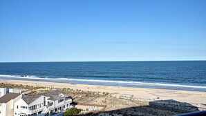 Une vue sur la plage, avec une maison au premier plan et l’océan en arrière-plan.