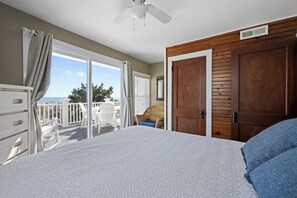 Une chambre à coucher avec un lit, une porte en bois et un balcon offrant une vue.